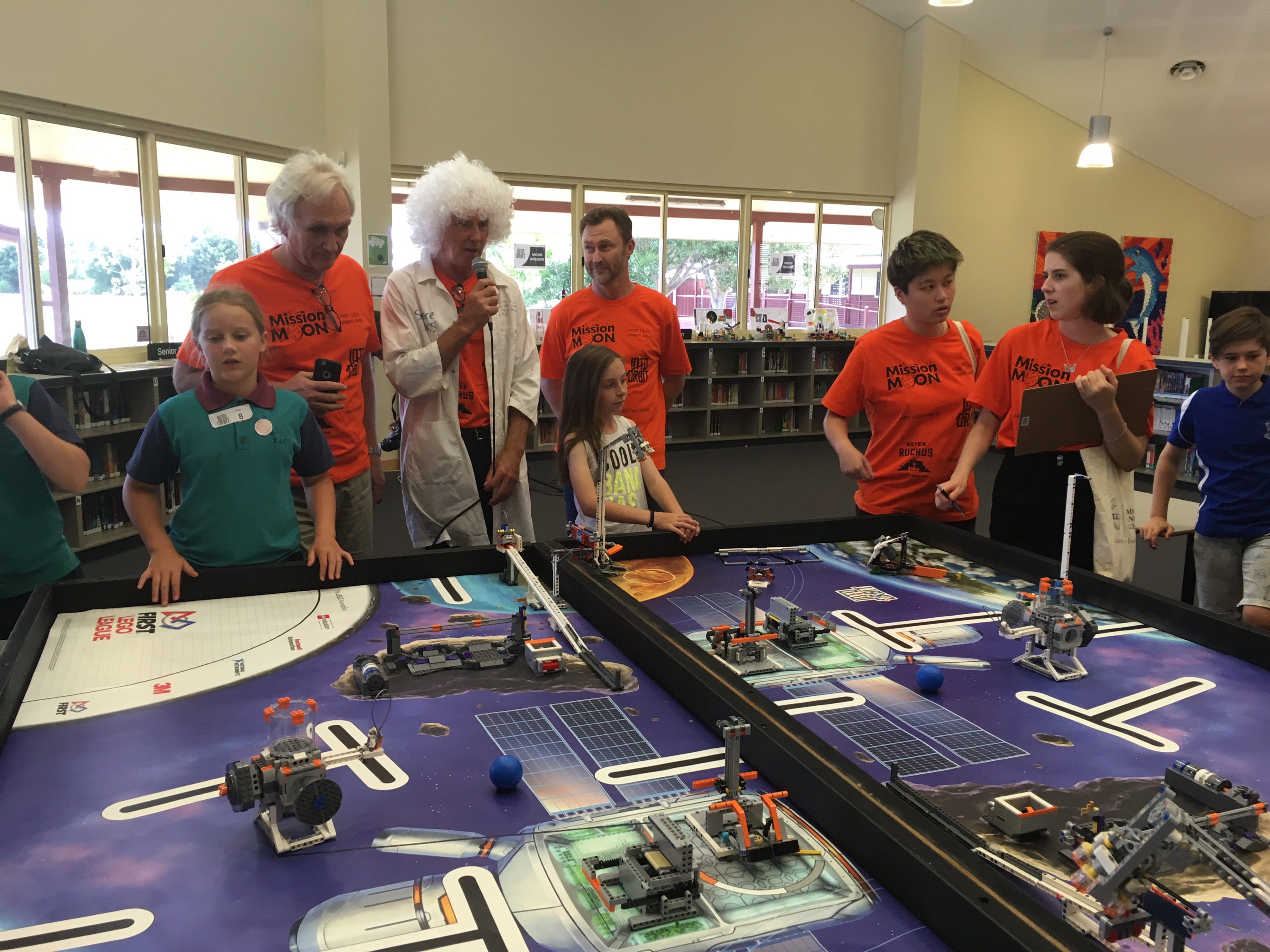 Lego Into Orbit Comp at EAC_BP Judging (2) Image of people looking at a table of lego models